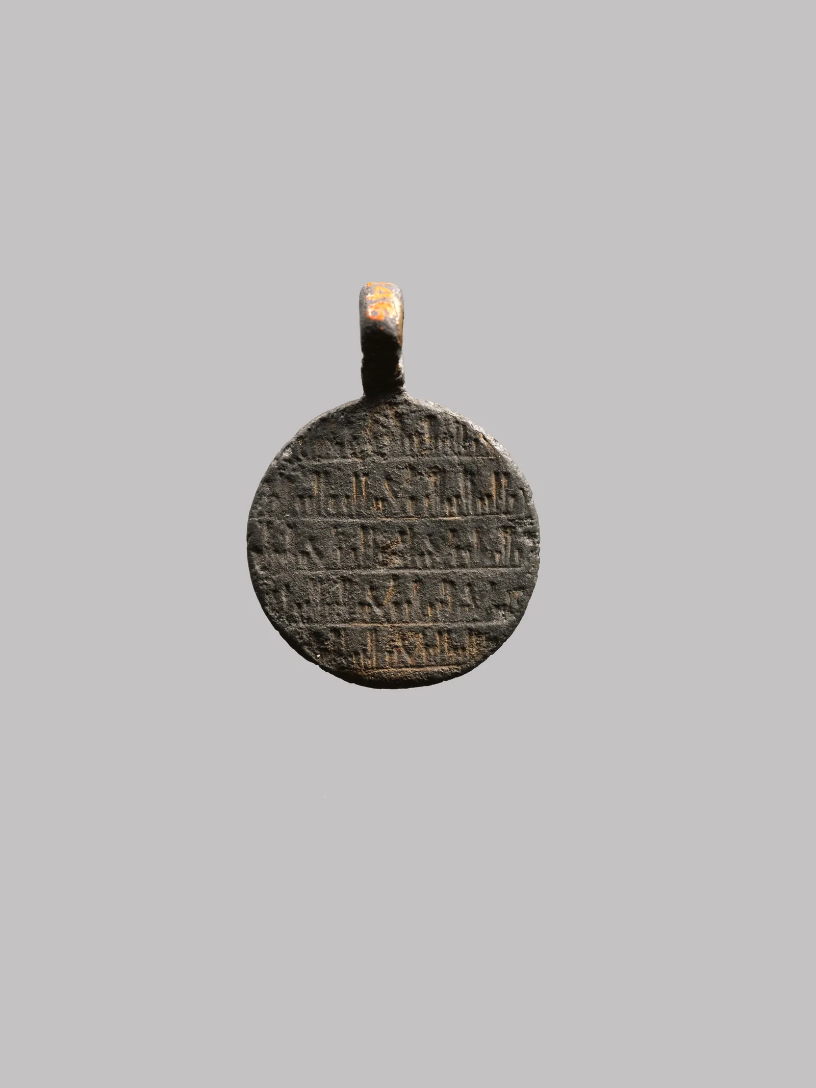 Silver amulet pendant with engraved figures of a lion and a scorpion and an Arabic inscription
