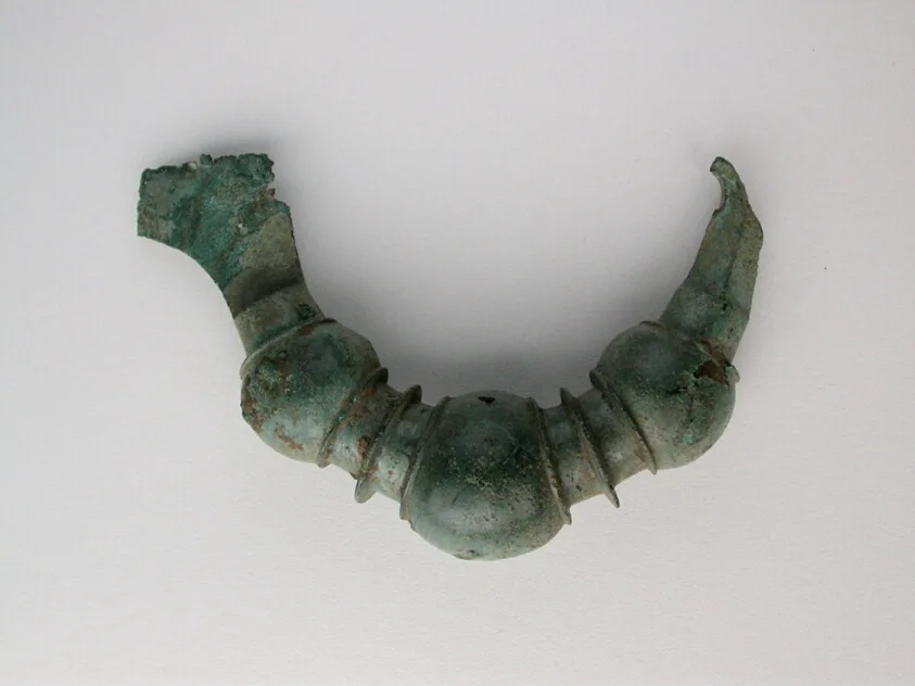 Dark bow brooch with a deep matte sheen, an ancestor of the carved black amulets and fibulae sold to pilgrims by the azabacheros of Compostela