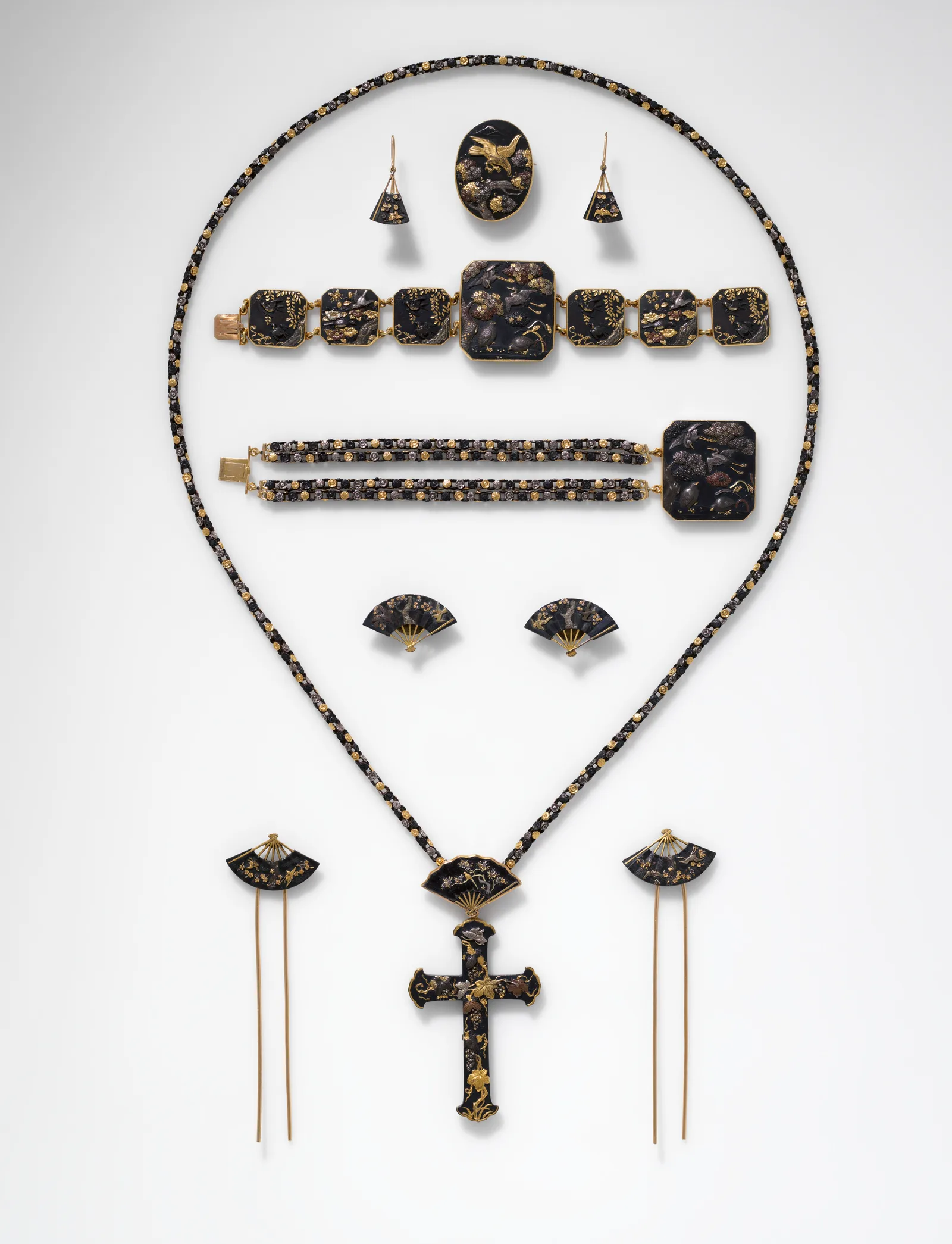 Aderezo de once piezas: collar con cruz, pendientes, broche, dos pulseras, horquillas y gemelos de shakudo oscuro con oro