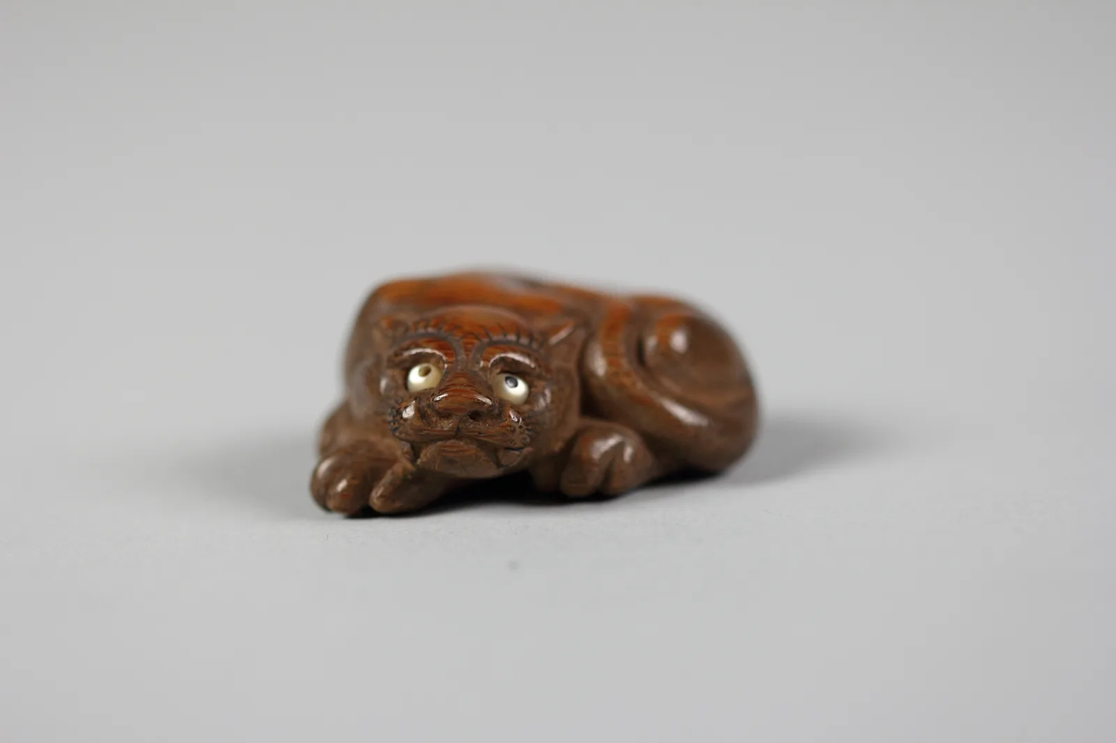 Netsuke en forma de tigre tumbado, tallado en boj, Japón, siglo XIX