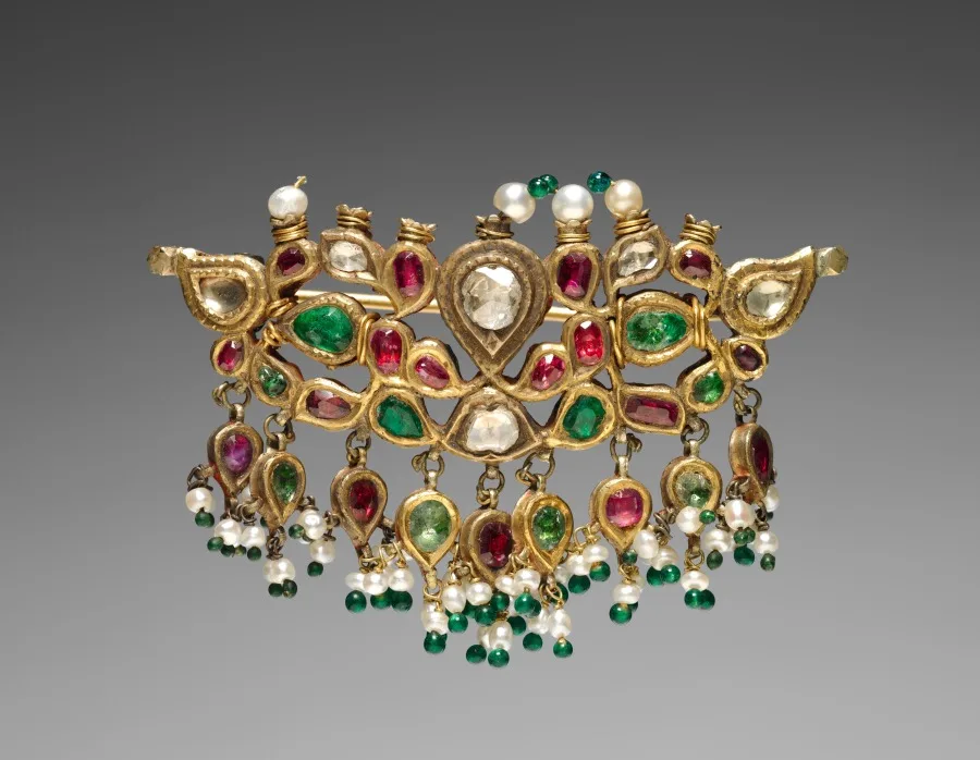 Antique brooch with a deep green stone in a metal setting