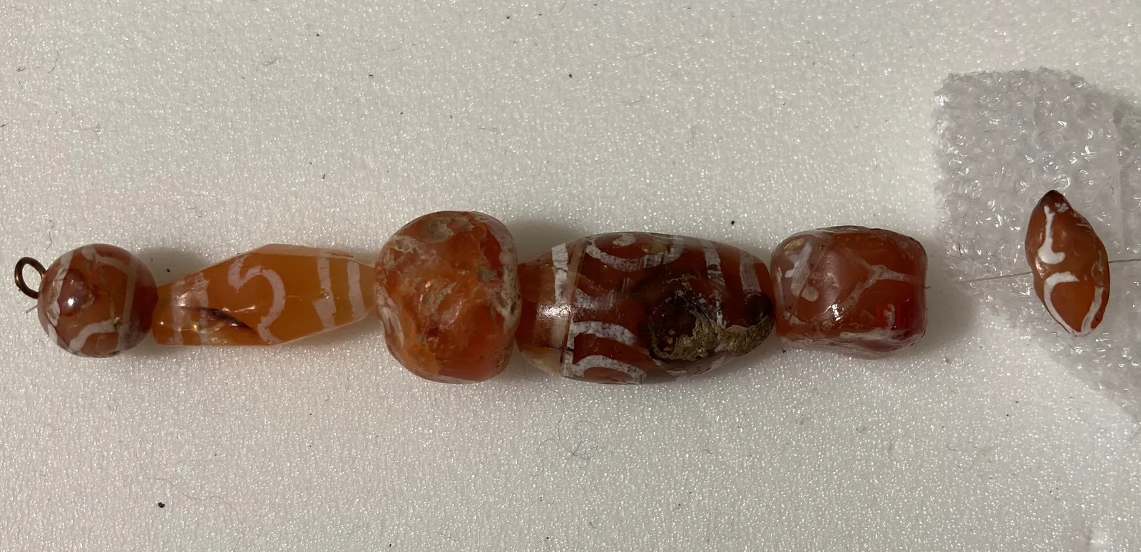 Perle intagliate in corniola con foro passante, una varietà di calcedonio quarzoso