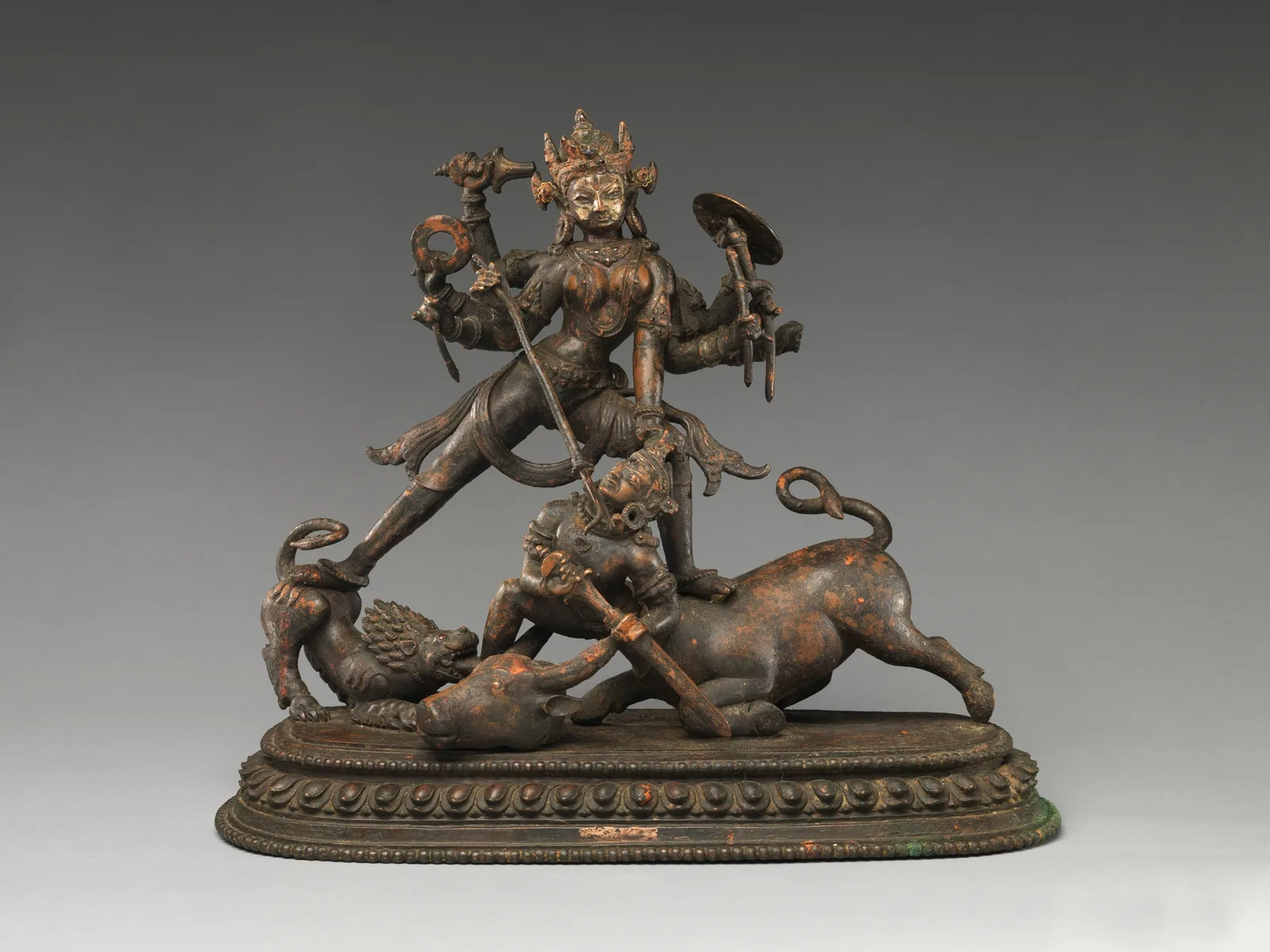 Escultura de bronce de la diosa Durga de muchos brazos venciendo al demonio búfalo Mahishasura