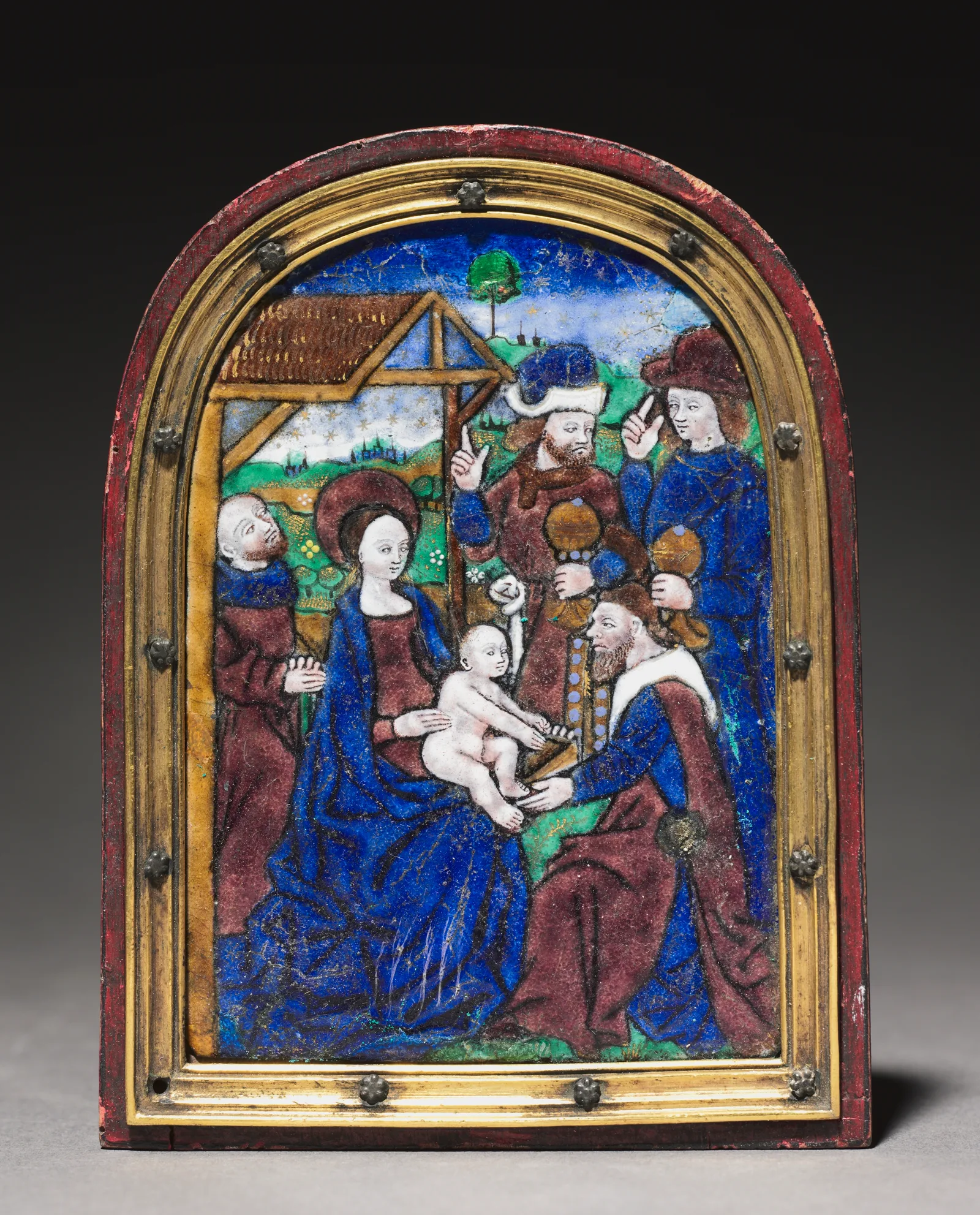 Placa de esmalte pintado de Limoges con remate en arco y marco dorado: un rey arrodillado ofrece un cofre al niño, sentado en el regazo de la Virgen