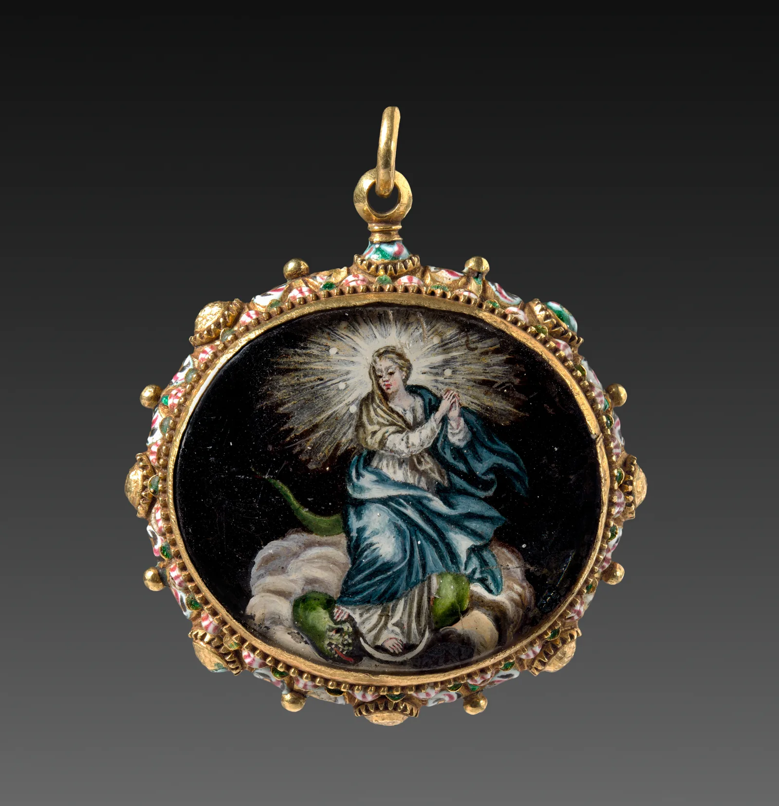 Colgante ovalado de metal dorado con esmalte, España, siglos XVII-XVIII: la Virgen con las manos juntas sobre nubes y media luna, pisando un dragón, con rayos de luz alrededor de la cabeza