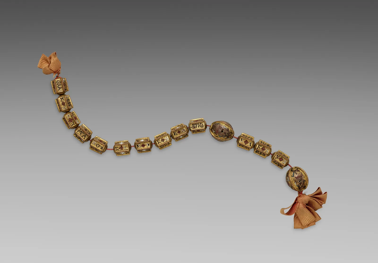 Tramo de rosario de cuentas de cobre dorado con esmalte y letras grabadas, con dos cuentas ovaladas más grandes y lazos de cinta en los extremos, Italia, principios del siglo XVI