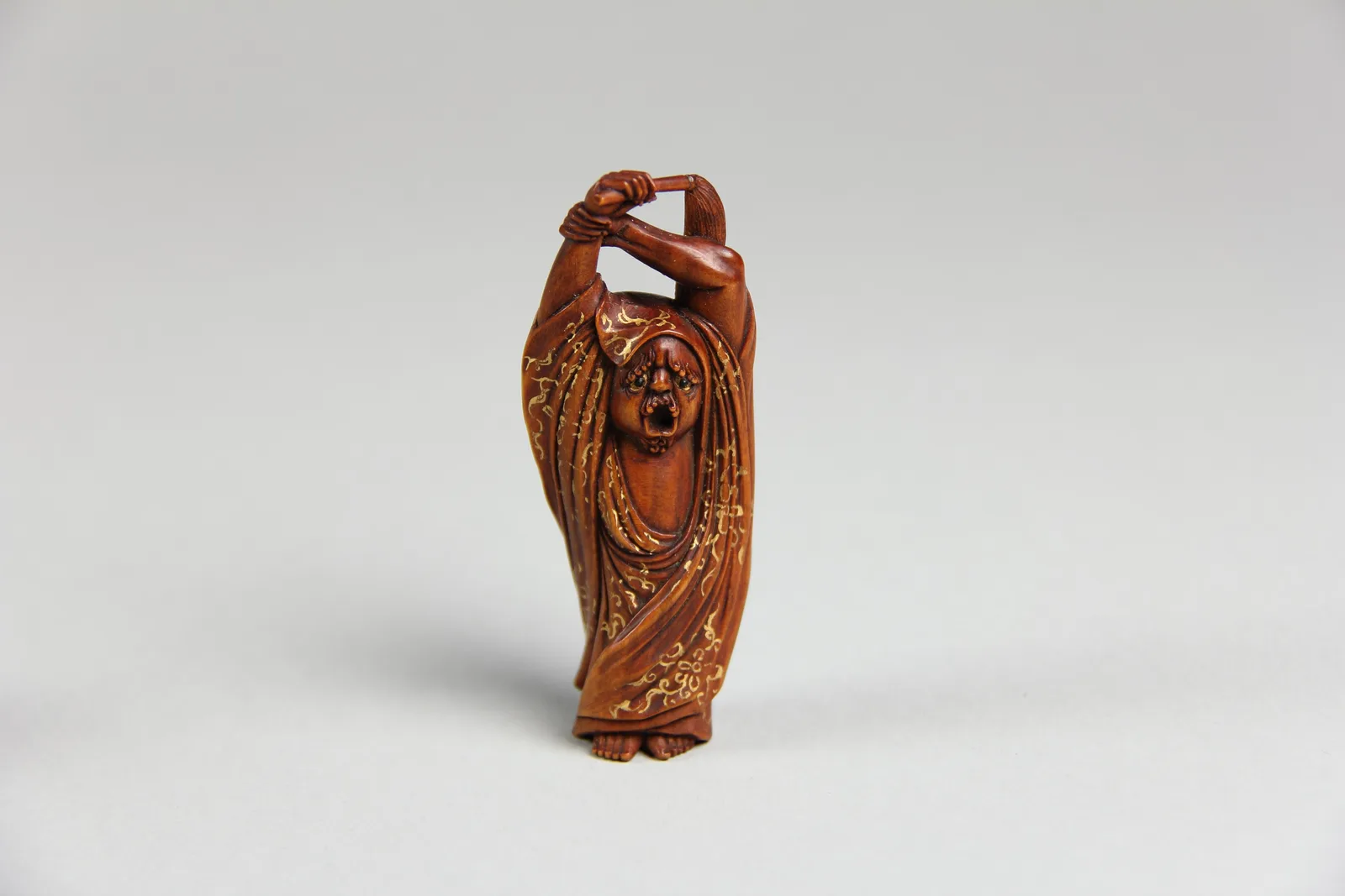 Geschnitzte hölzerne Netsuke in Form einer Daruma-Figur, mit Gold verziert