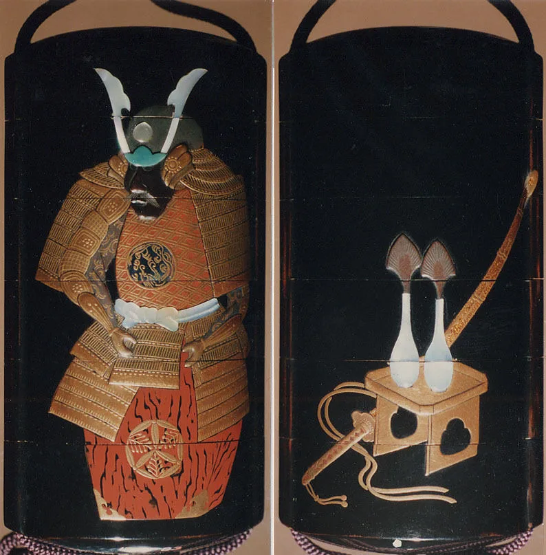 Japanisches Inro aus goldenem und farbigem Lack mit einer Netsuke in Daruma-Form aus Ebenholz