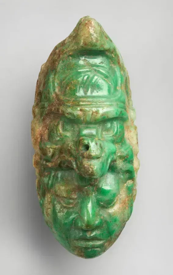 Pendente maya in giadeite con volto intagliato e tracce di pigmento, 600 a 700 d. C.